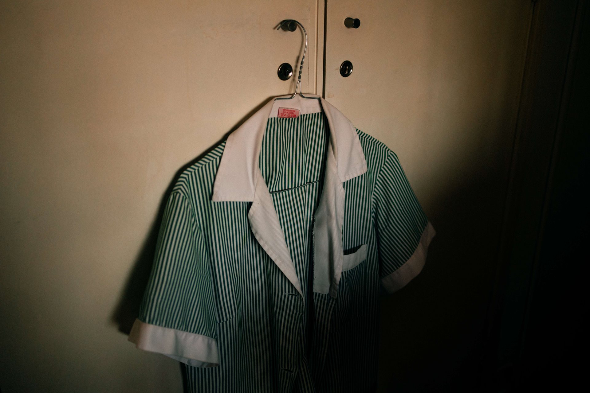 One of Ana Maria&rsquo;s uniforms hangs ready for work, in Lisbon, Portugal.